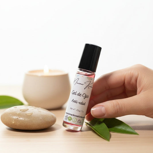 monimarkreations AgeLuxe Anti-Aging Eye Gel in a rollerball bottle with a black cap, on a fluffy white background.